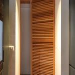 Volets Guignard en bois avec lamelles, intégrés dans un hall moderne.