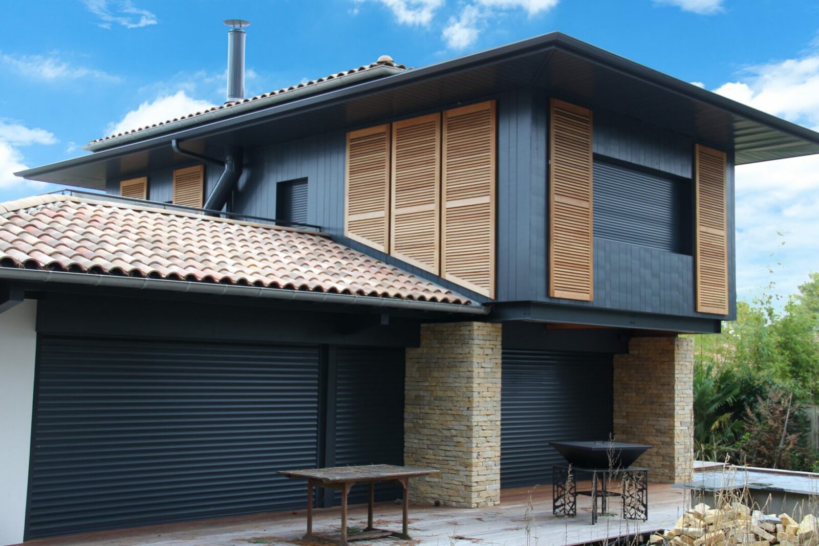 Maison moderne avec volets en bois et tuiles rouges.
