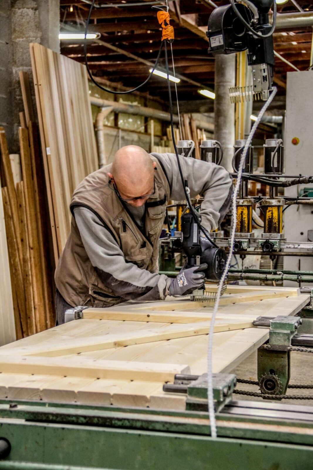 Un artisan travaillant sur des volets Guignard en atelier.