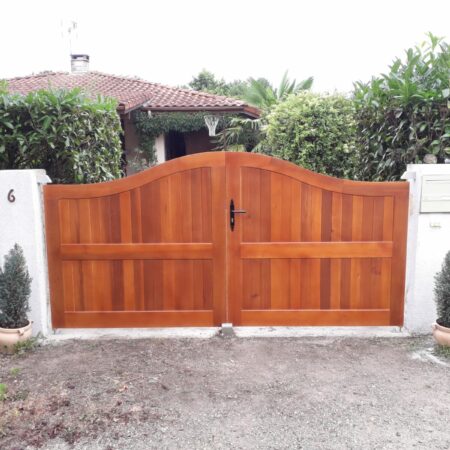 Volets en bois rouge, maison avec toit en tuiles rouges, buissons verts