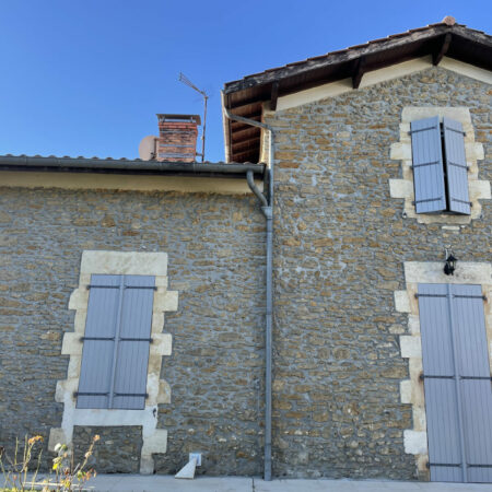 Ancienne maison en pierre avec volets gris