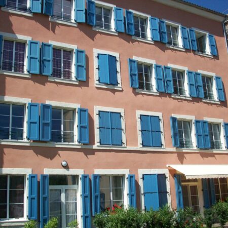 Volets bleus sur bâtiment rose